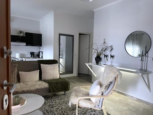 a white living room with a couch and a chair at Zoe's House in Polykárpion