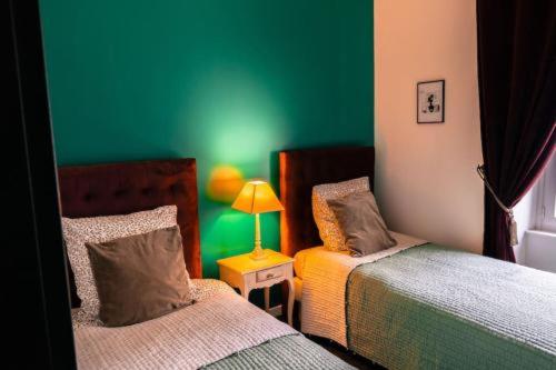 1 Schlafzimmer mit 2 Betten und einer grünen Wand in der Unterkunft CORTO 4 pers Cœur Vieille Ville Parking in Boulogne-sur-Mer