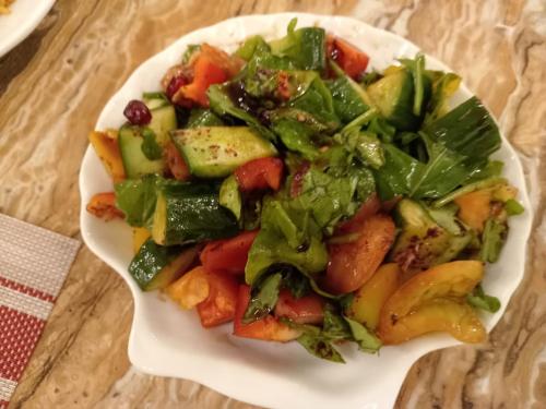 a salad on a white plate on a table at Petra Premium Hotel in Wadi Musa
