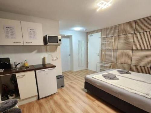 a bedroom with a large bed and a kitchen at Stuttgart City Apartment A in Stuttgart