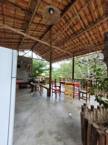 ein Pavillon mit Tisch und Stühlen in einem Raum in der Unterkunft Nosso Quintal Candeias - Cabana Flamboyant in Conceição do Mato Dentro