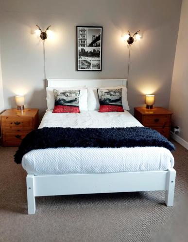 a bedroom with a large white bed with two lamps at Kings in Ballyconneely