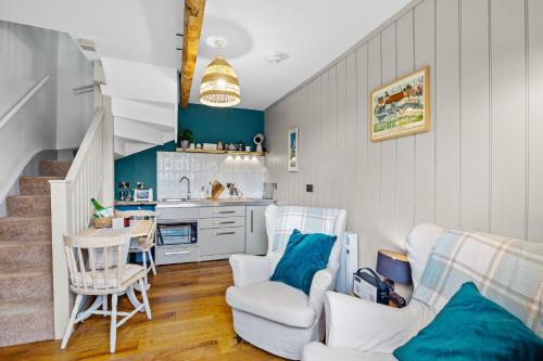 a living room with a table and chairs and a kitchen at Welsh Cottage in Little Marcle