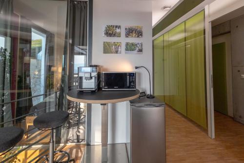 a kitchen with a table with a microwave on it at Apartment "Wild Berry" - Business-20 qm-ruhig-Parkplatz-Arbeitsplatz in Leonberg