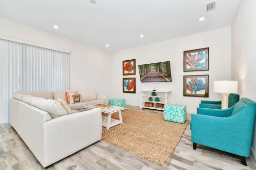 a living room with a white couch and blue chairs at Margaritaville Cottages Orlando with H2O Waterpark by Rentyl in Kissimmee