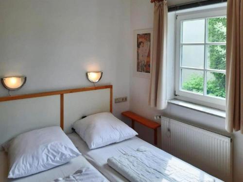 a bedroom with two beds and a window at Ferienwohnungen Blaues Haus, Putbus in Putbus