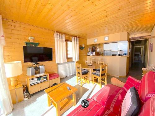 un salon avec un canapé rouge et une table dans l'établissement T3 Plein Sud - Proche remontées mécaniques, à L'Alpe-d'Huez