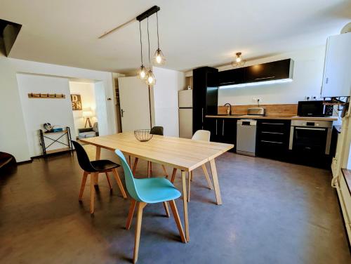une cuisine avec une table et des chaises en bois dans l'établissement Appartement tout équipé de 2 chambres a charmes, à Charmes