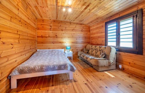 a bedroom with a bed and a couch in a room at Uroczy Zakatek in Chłopy