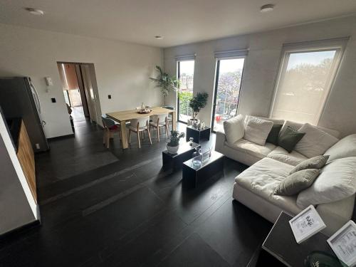 a living room with a couch and a table at Apartment with balcony in the heart of the city in Mexico City
