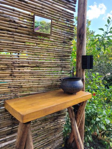 eine Holzbank mit einer Vase darüber in der Unterkunft Nosso Quintal Candeias - Camping in Conceição do Mato Dentro