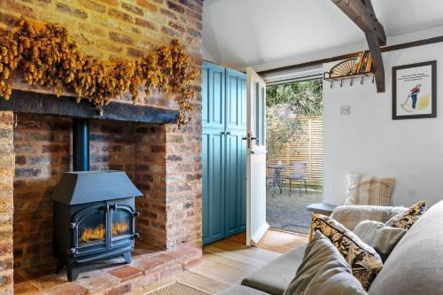 a brick fireplace in a living room with a stove at The Hop Store in Little Marcle