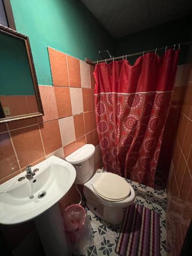 a bathroom with a toilet and a sink at Valerie Emanuel Apartments in Bocas del Toro