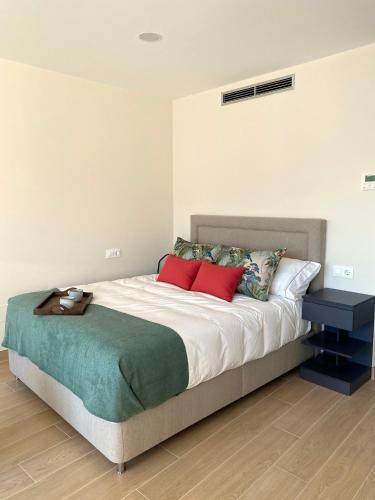 a bedroom with a large bed with red pillows at Alojamientos Ría de Vigo & Alborada in Moaña