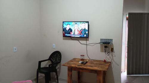 Una habitación con una mesa y un televisor en una pared. en Hotel - Pousada e Restaurante Dona Benta, en Novo Acordo