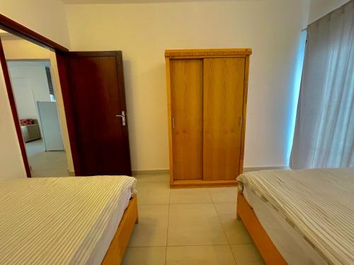a bedroom with two beds and a wooden door at Nile Panorama Hotel in Luxor