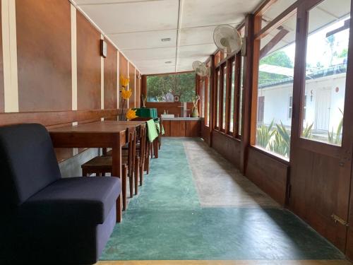 a dining room with a green floor and a table and chairs at Ago Hotel and Villa in Katunayake