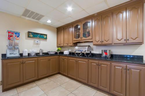 a kitchen with wooden cabinets and black counter tops at Red Roof Inn Augusta – Washington Road in Augusta