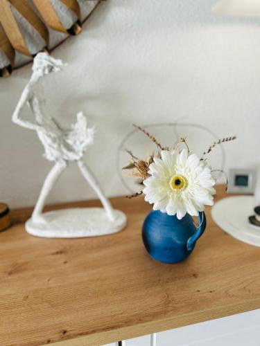 un vase bleu avec une fleur blanche sur une table dans l'établissement 