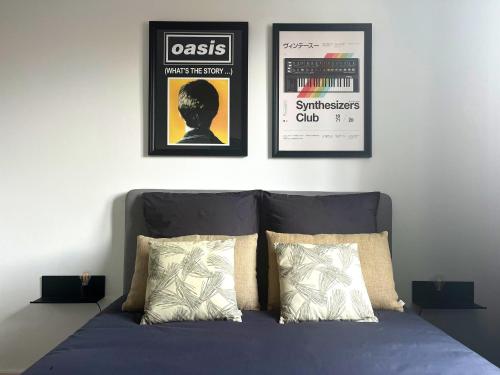 un lit avec trois affiches encadrées sur un mur dans l'établissement T3 - Route Espagne - Autoroute A64 2min - Parking, à Portet-sur-Garonne