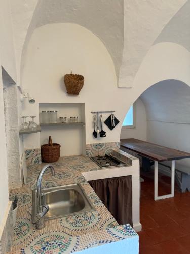 a kitchen with a sink and a table at Al Palazzotto in Pantelleria