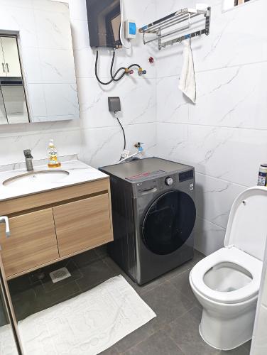 a bathroom with a washing machine next to a toilet at Eika - Refined and luxurious studio Apartment in Nairobi