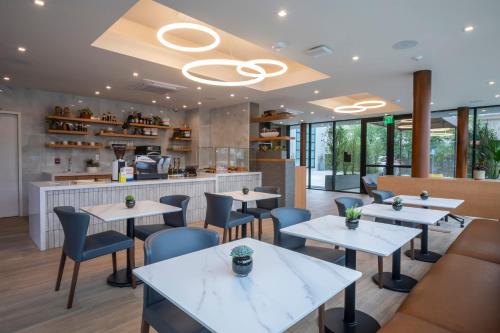 a restaurant with tables and chairs and a bar at Olivia Hotel in Los Angeles