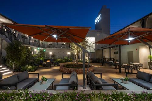 a patio with furniture and umbrellas at night at Olivia Hotel in Los Angeles