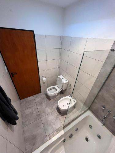 a bathroom with a toilet and a bath tub at Departamento en Complejo in Cavalango