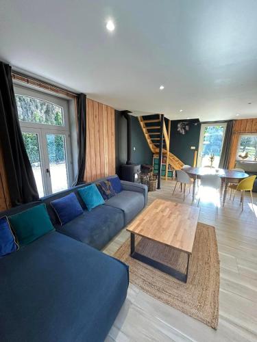 a living room with a blue couch and a table at L'arche De Noé in Dinant