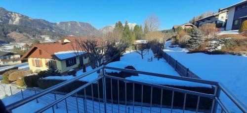 a balcony with snow on the ground next to a house at Panoramatraum in Gersdorf
