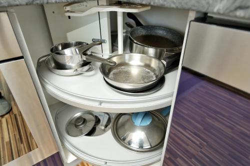 a kitchen with three pots and pans on a shelf at Panoramatraum in Gersdorf
