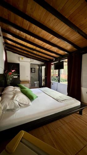 a large bed with white sheets and green pillows at Hotel Premium Real in Medellín