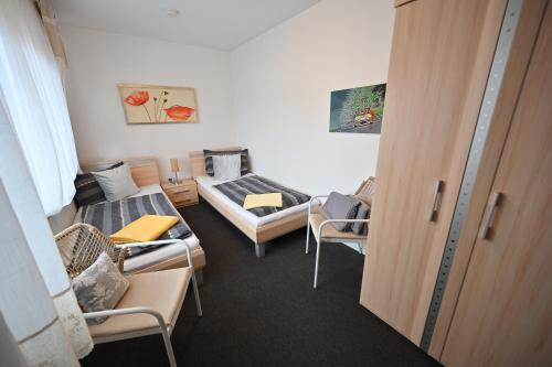 a room with two beds and a room with chairs at Apartment Paradiso in Kelberg