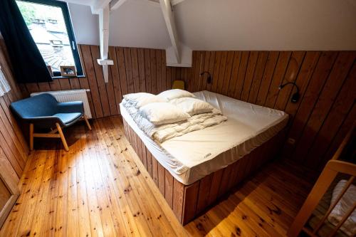 a bedroom with a bed and a blue chair at L'arche De Noé in Dinant