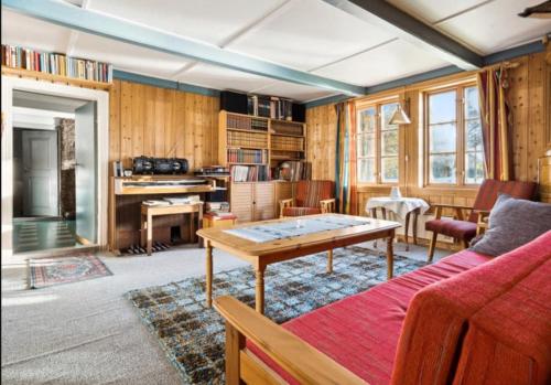 a living room with a red couch and a table at Lofoten Farm House in Vestvågøya