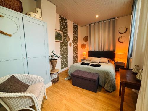 une chambre avec un lit et une chaise dans l'établissement jolie cottage idéalement située, à Honfleur