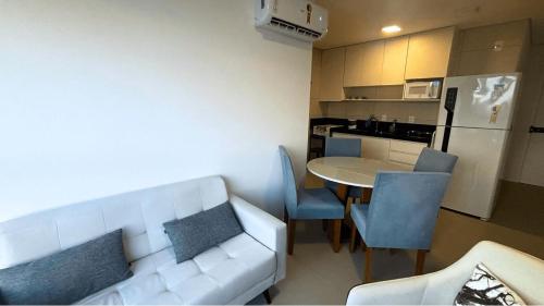 a living room with a white couch and a table at Parque do Cais - Flats Premium no Recife por Yolo in Recife