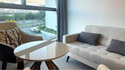 a living room with a couch and a table and a window at Parque do Cais - Flats Premium no Recife por Yolo in Recife