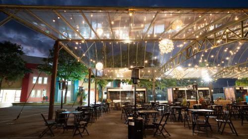 a group of tables and chairs under a building with lights at Tauá Hotel & Convention Atibaia in Atibaia