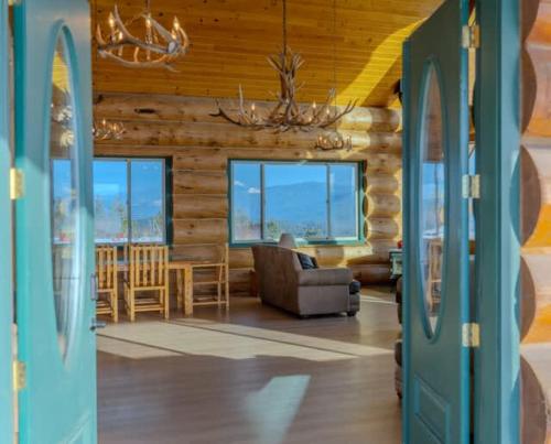 a log cabin with a living room and dining room at FoxHill Family Lodge Retreat with views from all sides and Hike over a hundred forty acres in Otis Orchards