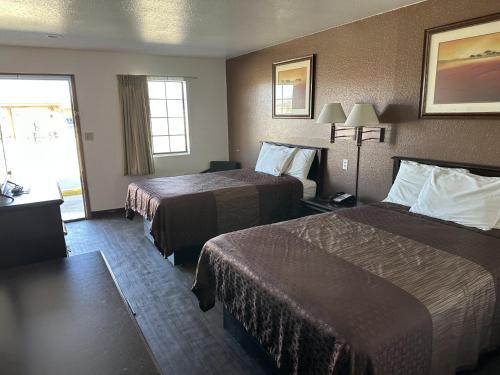 WaldronにあるSouthern Nights Motelのベッドが2つと窓があるホテルの部屋