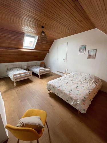 une chambre avec deux lits et une chaise dans l'établissement Le Clos des galets, à Audresselles