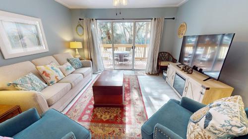 a living room with a couch and a tv at Edisto on my Mind in Edisto Island