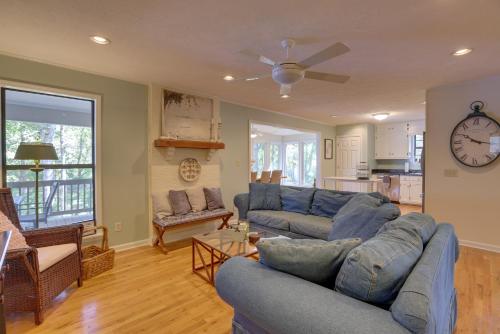 a living room with two blue couches and a clock at Lakefront Lineville Retreat with Private Dock! in Lineville