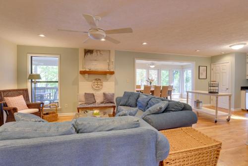 a living room with blue couches and a ceiling fan at Lakefront Lineville Retreat with Private Dock! in Lineville