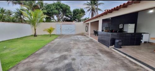 a house with a driveway with a yard with palm trees at Ilhéus Bahia beach houseia in Ilhéus