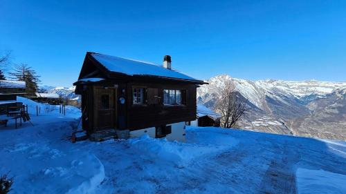 a small cabin in the snow with mountains in the background at Mayen La Grangette, bulle d'évasion in Nendaz
