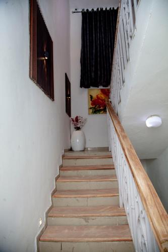 a staircase with wooden steps and a vase of flowers at Sultan Apartments Lagos in Lagos