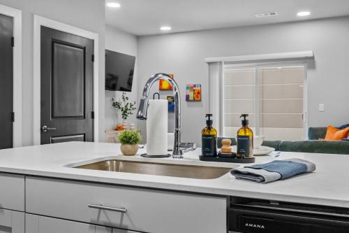 a kitchen counter with a sink and bottles of wine at Modern Apt W Pool, Gym & Free "p"prime Location in Rogers